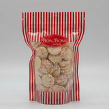 A red and white striped resealable bag of bon bon sweets pouches filled with round cookies topped with colorful sugar coatings