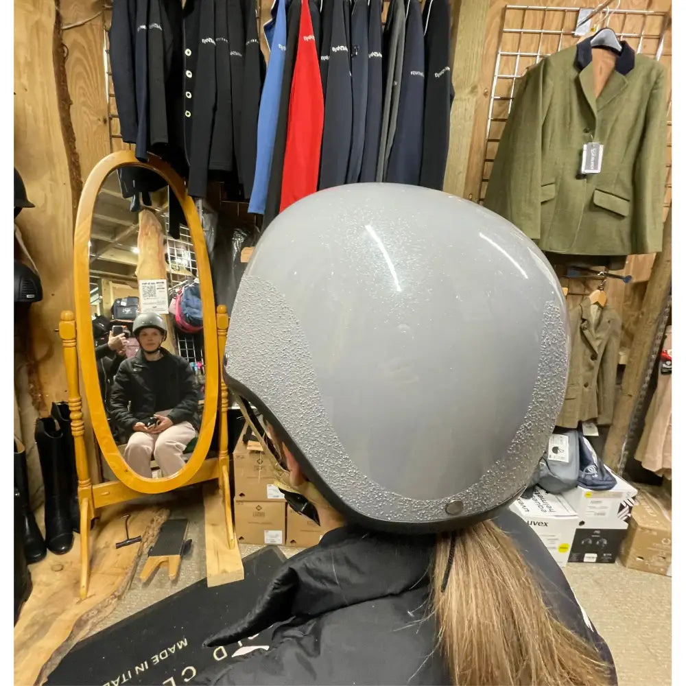 Gray equestrian helmet with speckled finish and black trim perfect for booking a fitting appointment with horses