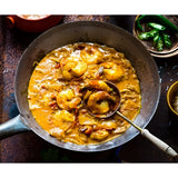 Rich golden-orange shrimp curry simmering in a cast iron skillet from boom kitchen ayubowan sri lankan recipe kit