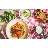 A vibrant orange and green curry in a white bowl with green rim from boom kitchen jalfrezi heatwave kit