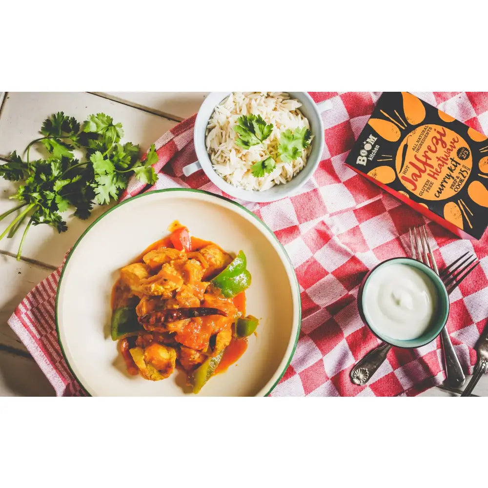 A vibrant orange and green curry in a white bowl with green rim from boom kitchen jalfrezi heatwave kit