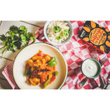 A vibrant orange and green curry in a white bowl with green rim from boom kitchen jalfrezi heatwave kit