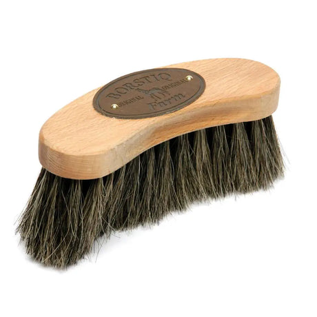 A light wood borstiq banana finishing brush with dark dense bristles and a bronze borstiq original farm plaque