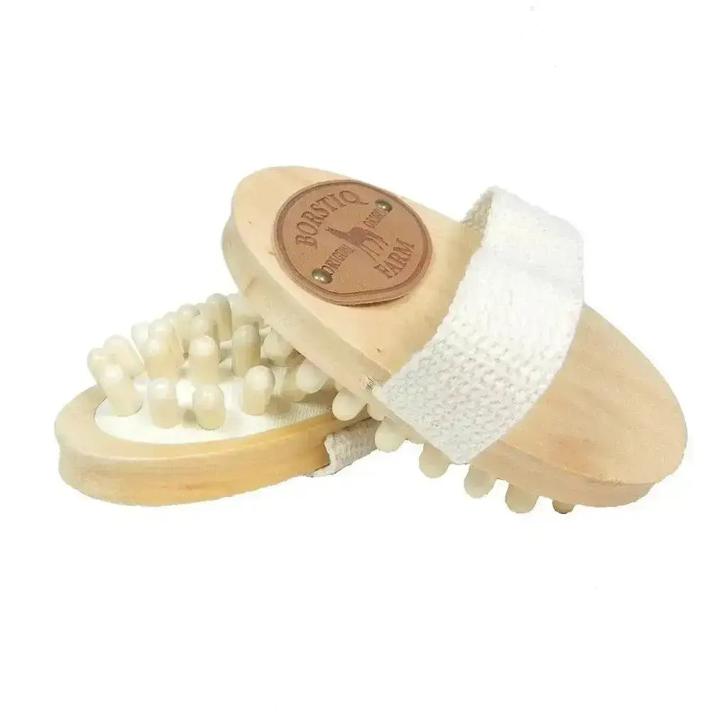 Light-colored wooden borstiq massage brush with white strap and cream-tipped nodes for horse grooming and borstiq massage