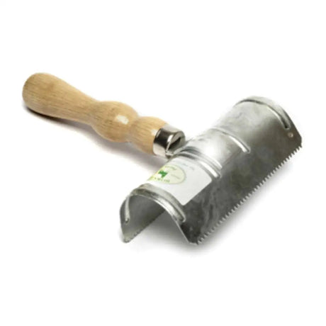 A borstiq metal curry comb with a metal lint roller, serrated edge, and light brown wooden handle in use