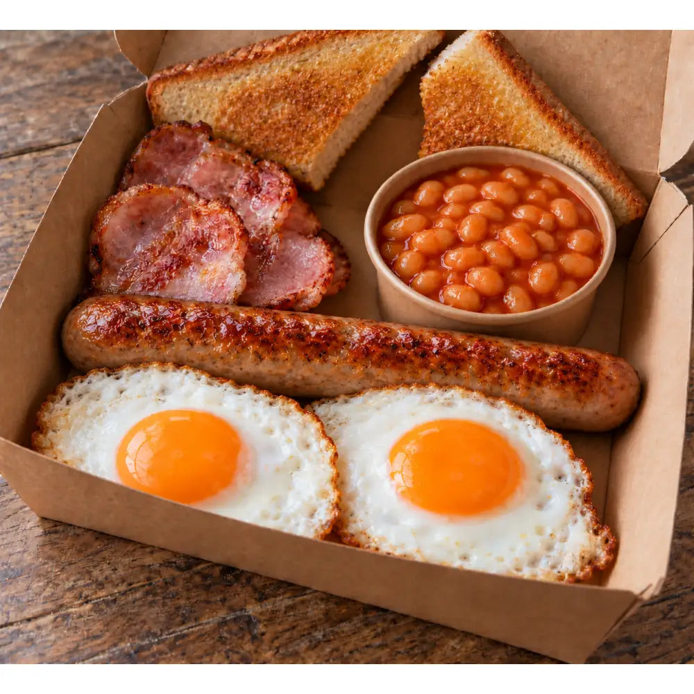 A loaded breakfast bap with sunny-side-up eggs, crispy bacon, grilled sausage, baked beans, and toasted bread triangles