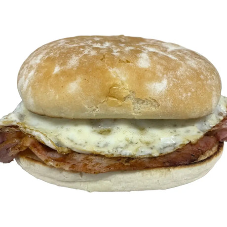 Golden-brown breakfast bap with crispy bacon fried egg and melted white cheese on wheat flour bun