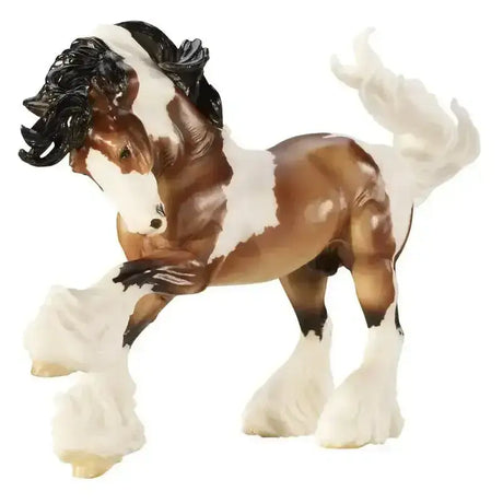 A detailed brown and white breyer gypsy vanner plastic model horse with black mane tail and hoof socks representing local traveler communities
