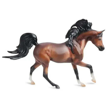 A detailed breyer mahogany bay arabian horse figurine with glossy finish and flowing mane and tail in brown and black