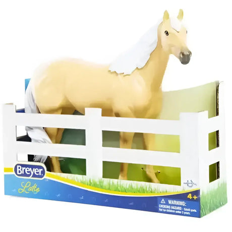 A pale gold breyer paddock pals latte palomino horse figurine with white mane and tail standing in packaging