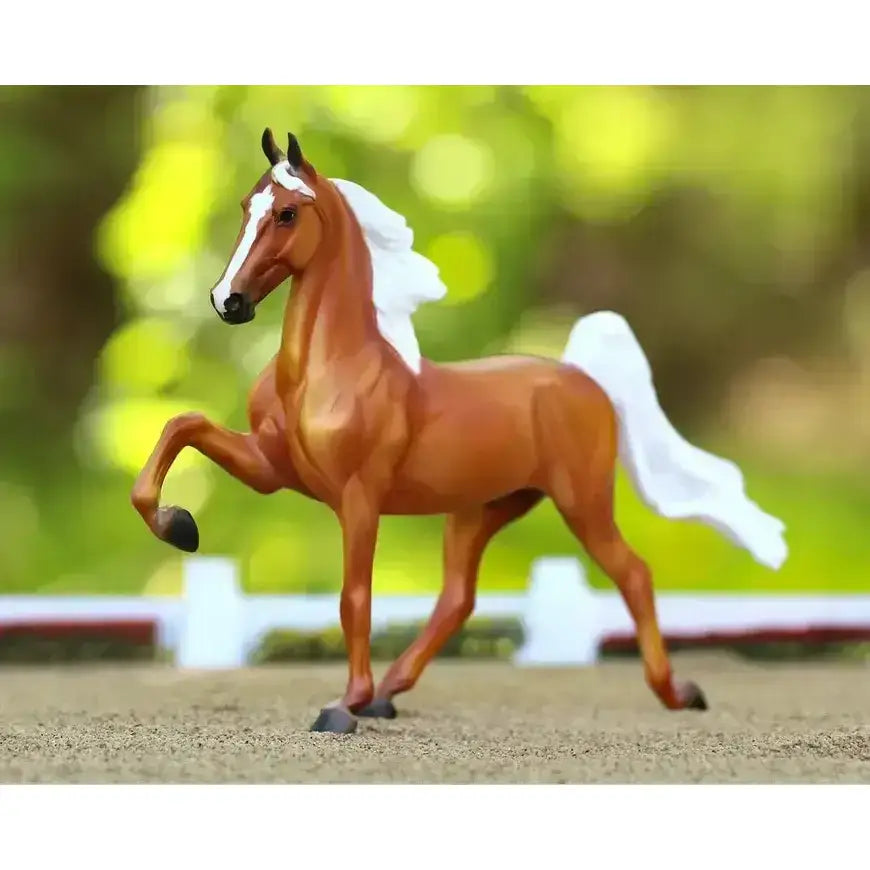 A detailed brown breyer palomino saddlebred horse figurine with white mane and tail and a glossy finish
