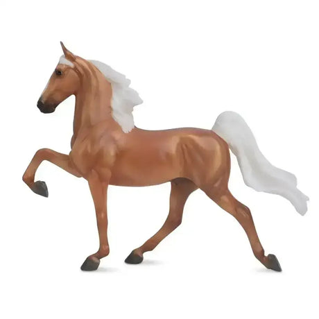 A detailed glossy tan breyer palomino saddlebred figurine with flowing white mane and tail