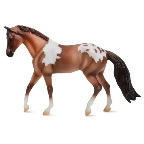 A detailed breyer red dun pintaloosa horse figurine with brown and white spots and a glossy finish