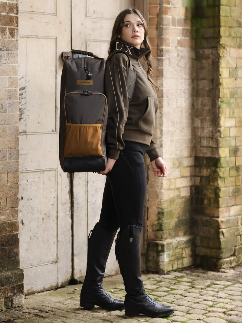 Brown and black equestrian backpack with a tan front pocket, featuring the ’equine’ brand label.