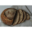 A rustic brown sliced sourdough rise bakery loaf with a dark flour-dusted crust and airy slow proofed interior