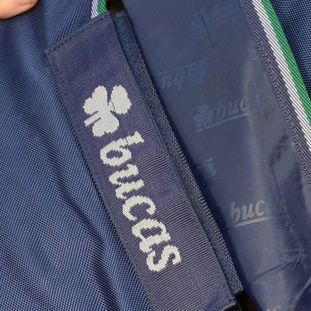 Dark blue woven fabric tag with white embroidered shamrock and bucas logo on bucas smartex pony rain sheet with stay-dry fleece