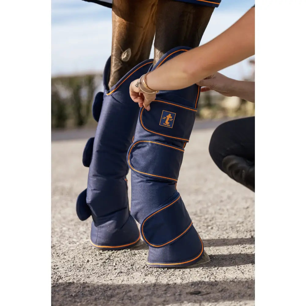 Navy blue bucas therapy travel boots with ripstop outer, orange stitching, padded horse leg wraps, small logo patch
