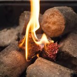 A burning reddish-brown burlyburn firelighter with charred fibers and bright orange flame for solid fuel appliances