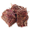 Two cube-shaped burlyburn firelighters made of dried red and brown plant fibers for solid fuel appliances
