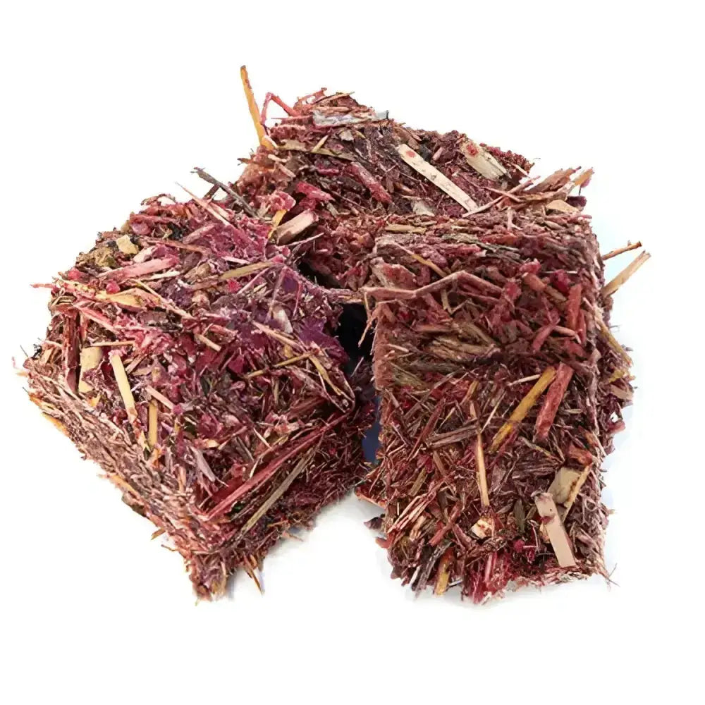 Two cube-shaped burlyburn firelighters made of dried red and brown plant fibers for solid fuel appliances