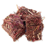 Two cube-shaped burlyburn firelighters made of dried red and brown plant fibers for solid fuel appliances