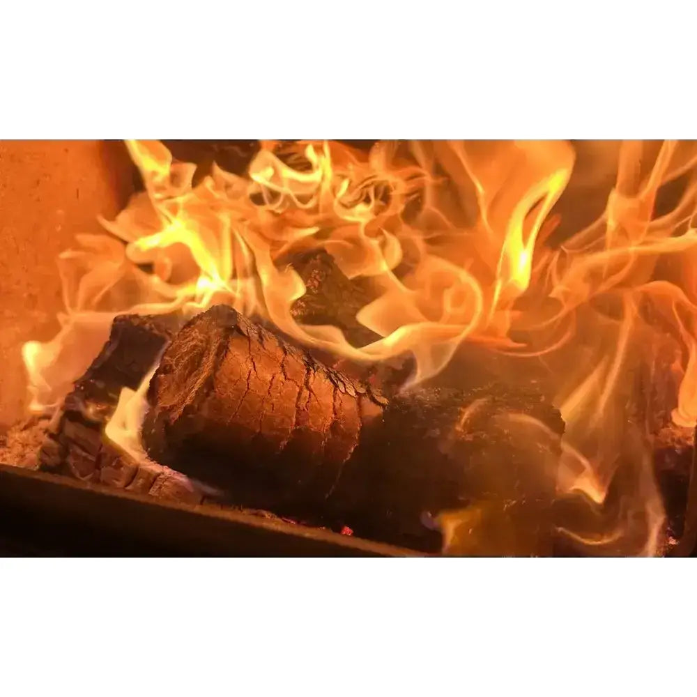 A crackling burlyburn solid fuel fire with vibrant orange yellow flames on dark charred logs showing heat logs use