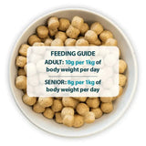 Light brown round kibble pellets of burns alert chicken dog food packed with amino acids hydrate in white bowl