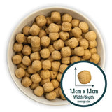 Tan round kibble pellets of burns original chicken dog food in a white bowl for healthy nutrition