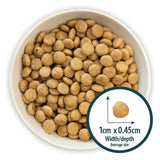 Brown round kibble pellets of burns toy small breed dog food with small breed chicken in a white bowl