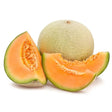 A whole cantaloupe melon with netted light green rind next to two bright orange slices showcasing juicy interior ideal for equestrian snacks