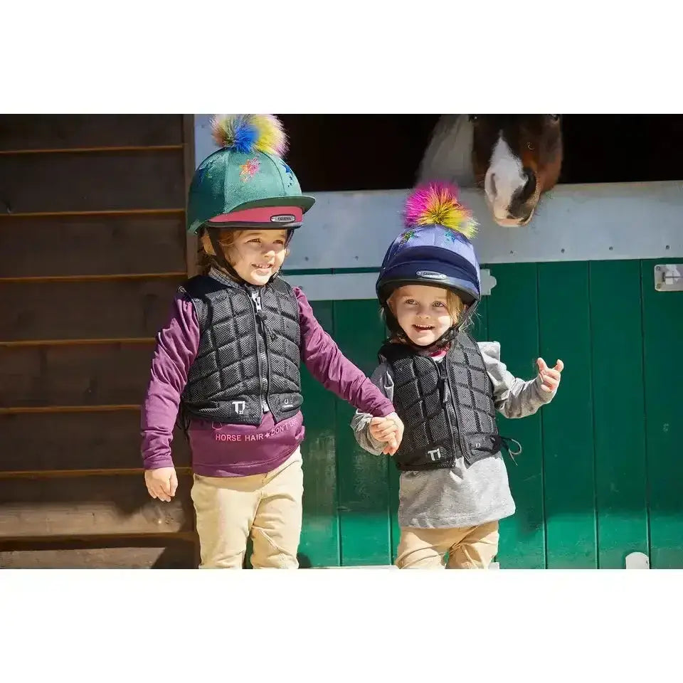 Two kids wearing colorful helmets and champion titanium ti22 infant body protectors for safe riding fun