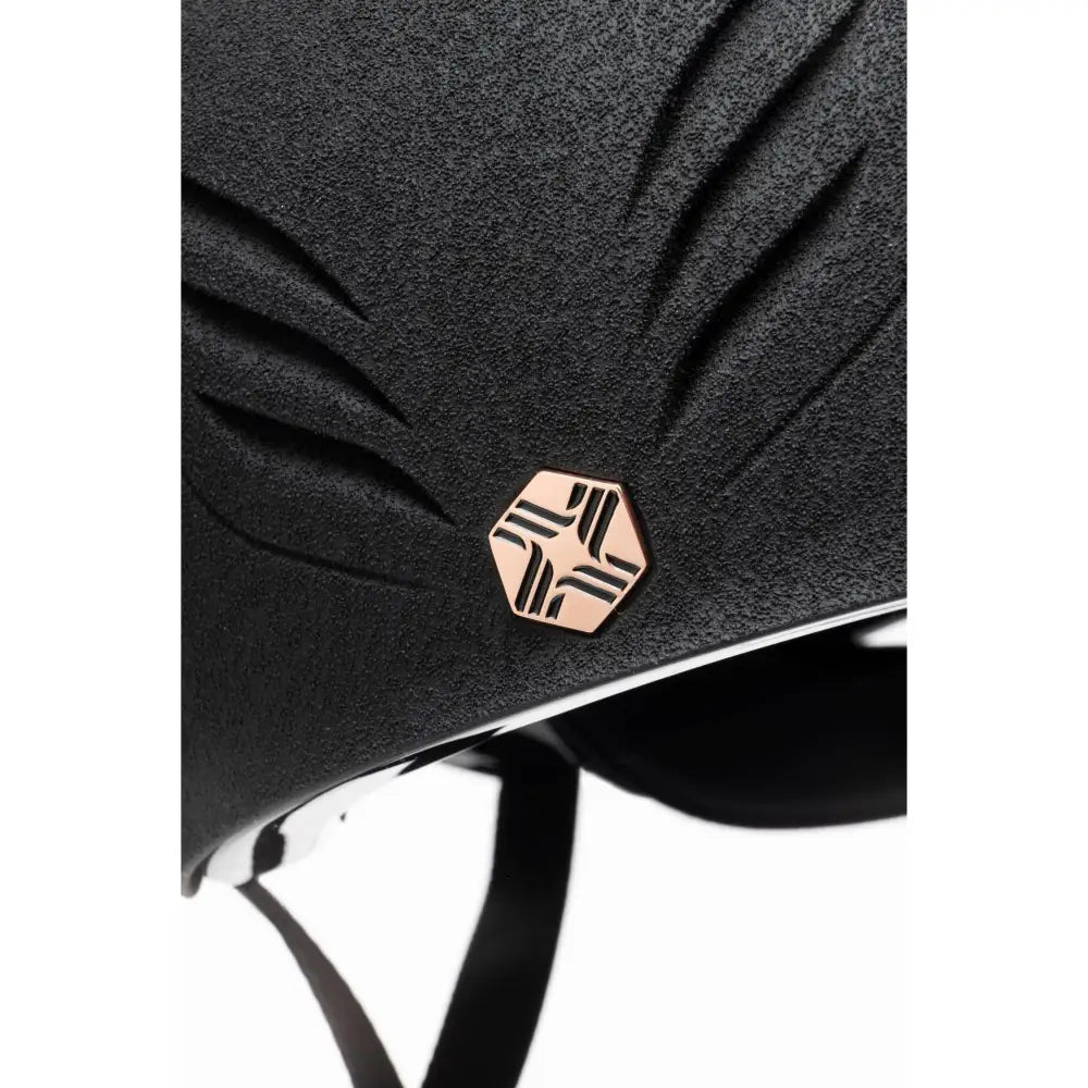 Black textured charles owen phoenix jockey skull equestrian helmet with rose gold hexagonal geometric emblem