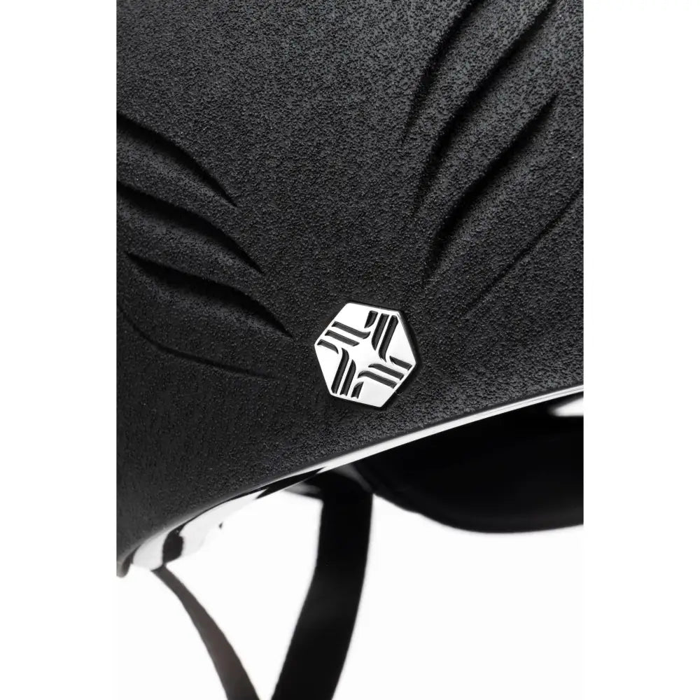 Black textured charles owen phoenix jockey skull helmet with sleek silver hexagonal geometric emblem