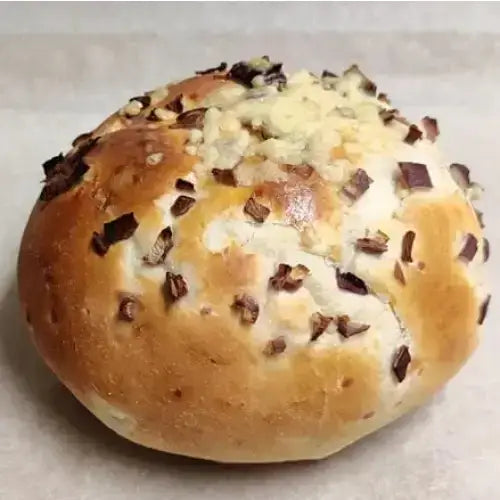 Cheese and onion round loaf with golden-brown crust topped with melted white cheese and chopped dark chocolate pieces