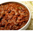 A rich red chilli con carne with beans and green peppers in a white bowl perfect for equestrian riders meals