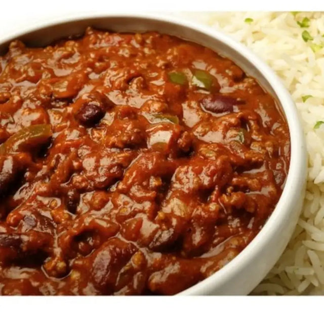 A rich red chilli con carne with beans and green peppers in a white bowl perfect for equestrian riders meals