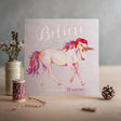 Soft pastel christmas card with santa & unicorns on eco kraft fleck textured board featuring pink purple mane