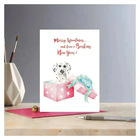 White christmas card rosa featuring a dalmatian puppy in a pink gift box with stars on eco kraft fleck paper