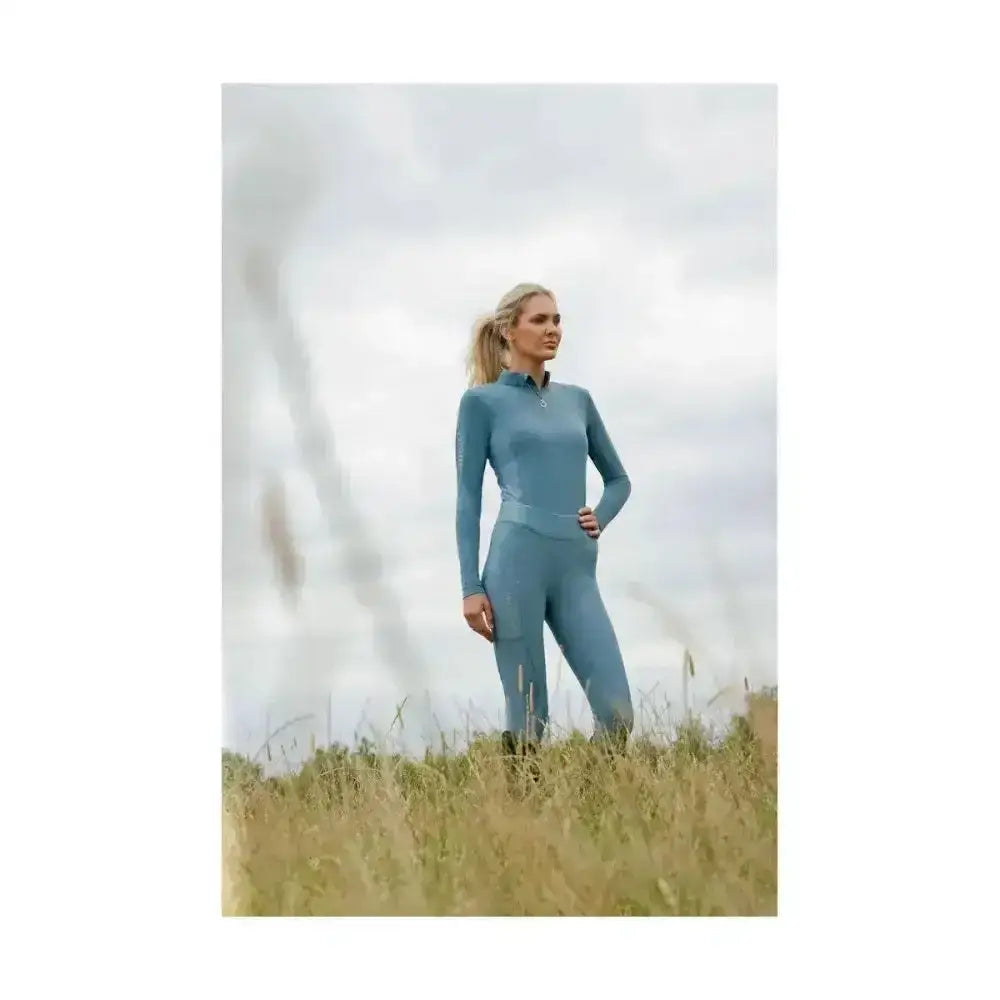 A sleek light blue coldstream ednam riding tights with high collar and technical capillary action fabric design