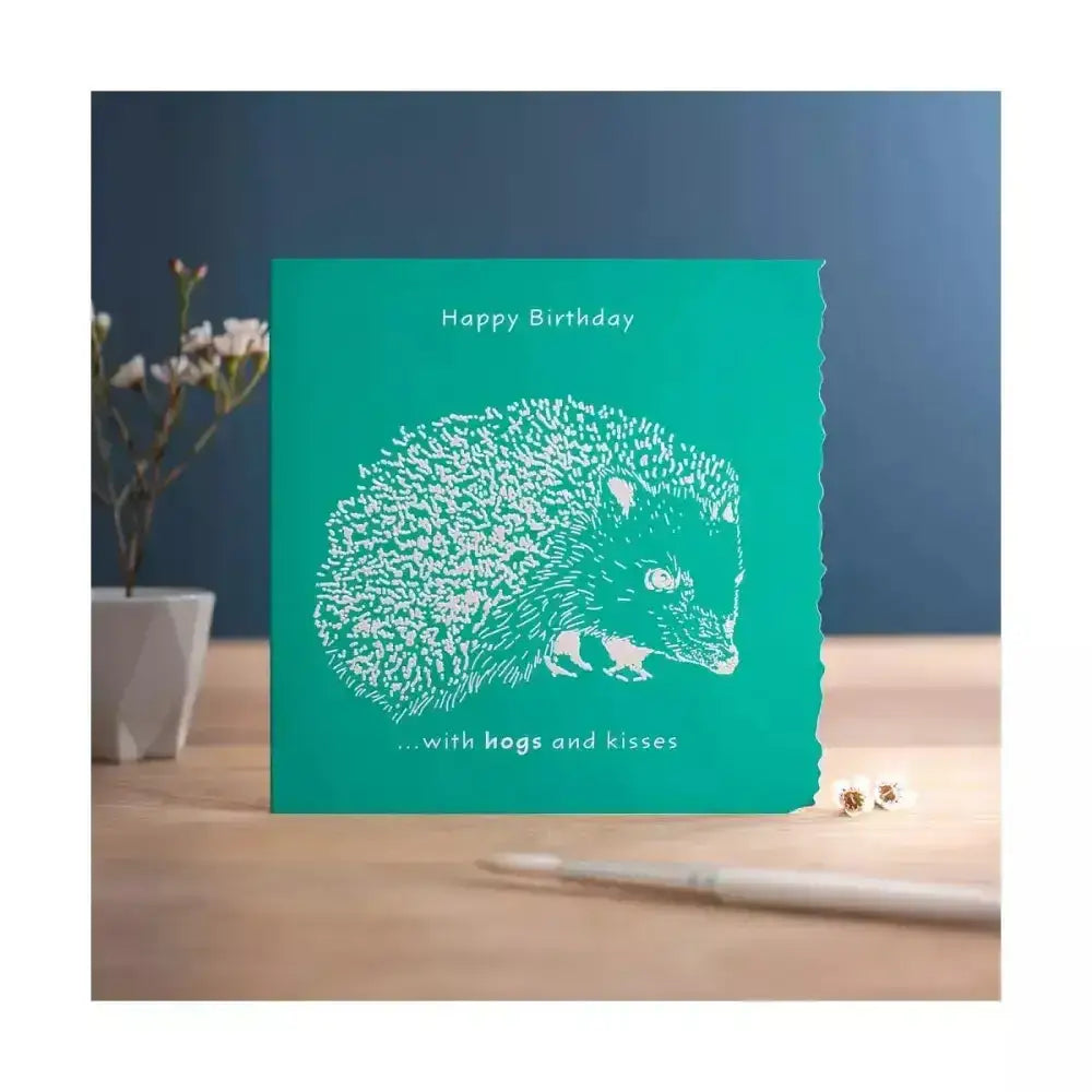 Teal colour block happy birthday card with white laser-cut hedgehog and happy birthday hogs and kisses text