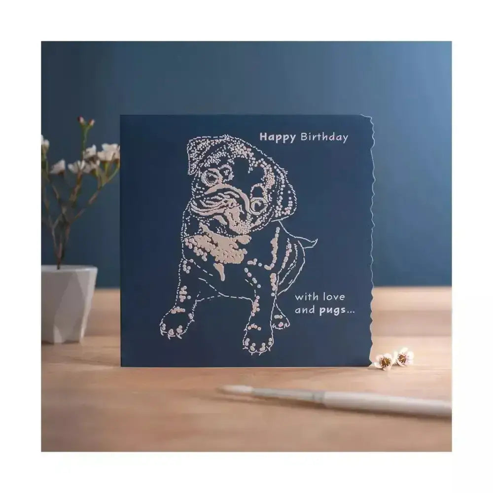 A navy blue colour block happy birthday card with a white laser-cut happy birthday pug design individually cello wrapped