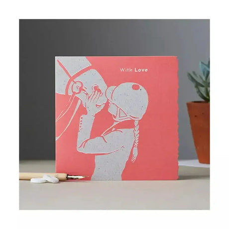 A coral colour block pony card with a white cut-out kissing couple and with love text, individually cello wrapped