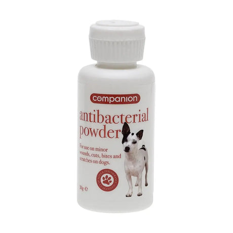 White plastic bottle of companion antibacterial powder for dogs with a red label and a black and white dog image pocket sized pack