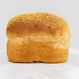 Golden-brown corn bread farmhouse loaf with sesame-seeded top and soft airy interior perfect as a round white bread
