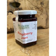 A square glass jar of country markets raspberry jam with white lid filled with deep red markets raspberry jam preserve