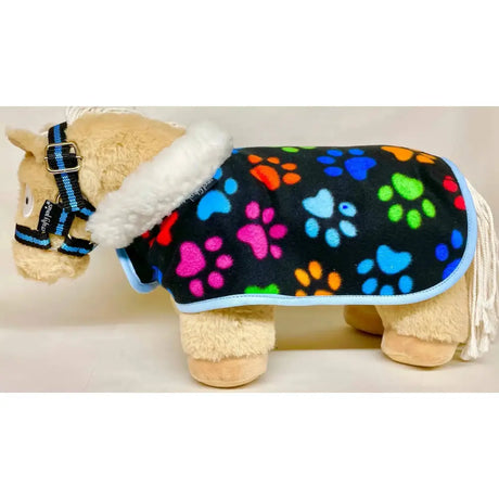 A plush toy horse wearing a black crafty ponies fleece neck show rug with rainbow paw prints and white faux fur trim