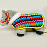 A plush gray horse wearing a crafty ponies fleece neck show rug with a colorful zigzag fleece blanket and yellow trim