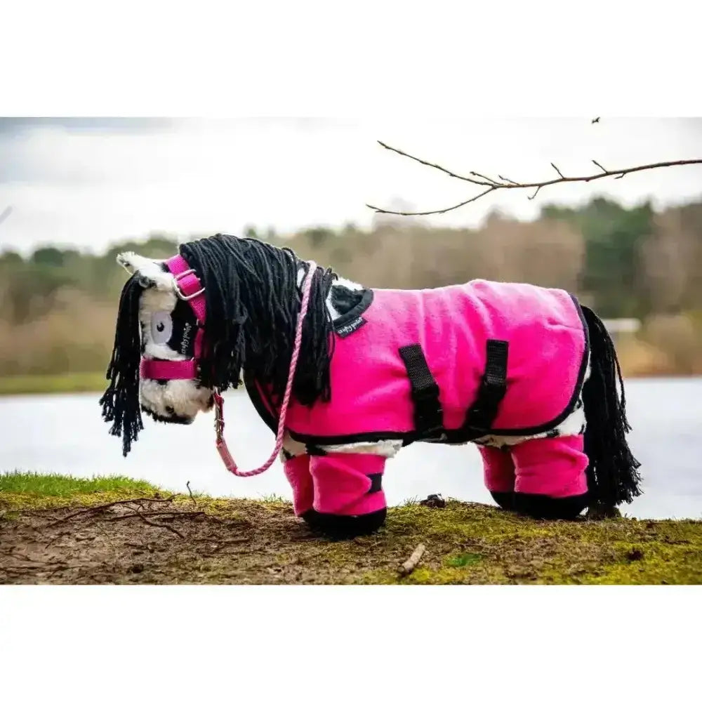A plush pink crafty ponies fleece horse toy with black yarn mane and tail wearing a ponies fleece rug with black straps