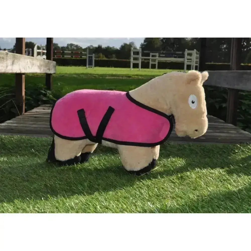 A plush beige horse wearing a vibrant pink crafty ponies fleece pony fleece rug with black trim and straps