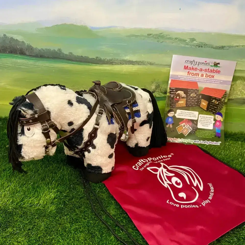A plush black and white spotted pony with brown leather tack from the crafty ponies western tack starter set